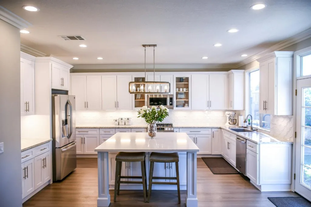 Sunlit white kitchen with sparkling clean windows and glass doors